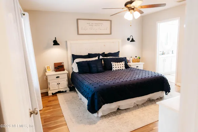 a bedroom with a bed and wooden floor