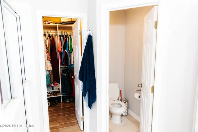 a view of walk in closet with clothes and shoes