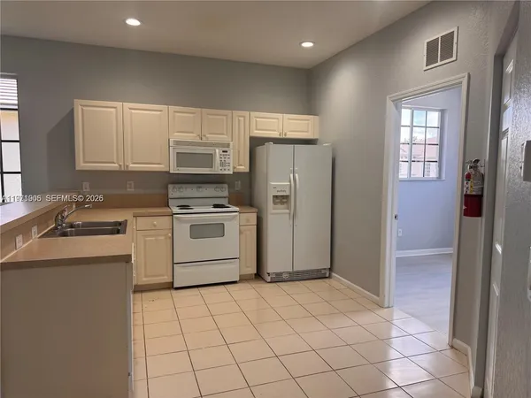 a kitchen with a stove a sink and a refrigerator