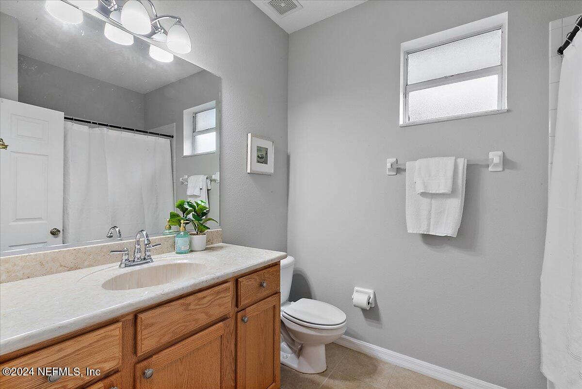 1053 Ridgewood Lane St. Augustine, FL 32086 - Photo 14 of 23 a bathroom with a granite countertop sink mirror and toilet