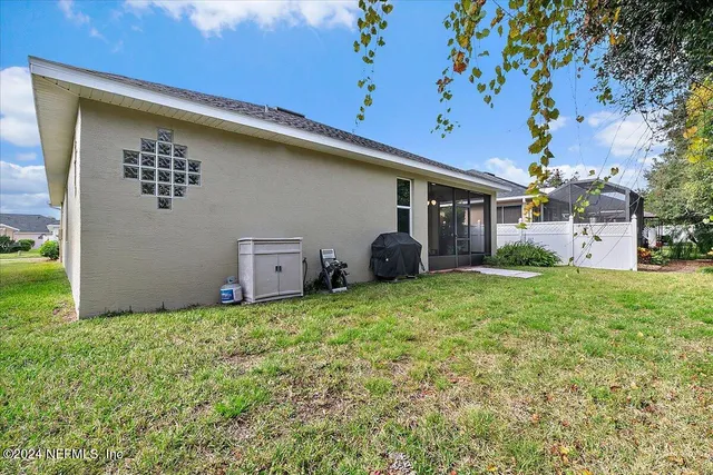a view of a house with backyard and a tree