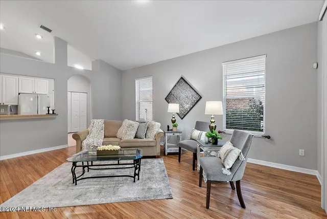 a living room with furniture wooden floor and a window
