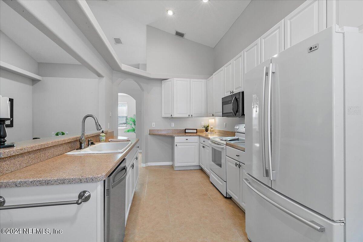 1053 Ridgewood Lane St. Augustine, FL 32086 - Photo 9 of 23 a kitchen with granite countertop a sink stainless steel appliances and white cabinets