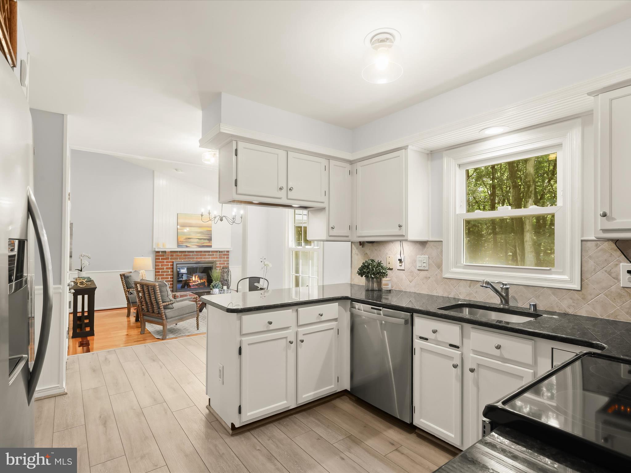 303 Riding Ridge Road Annapolis, MD 21403 - Photo 12 of 43 a kitchen with a sink dishwasher a stove and white cabinets with wooden floor