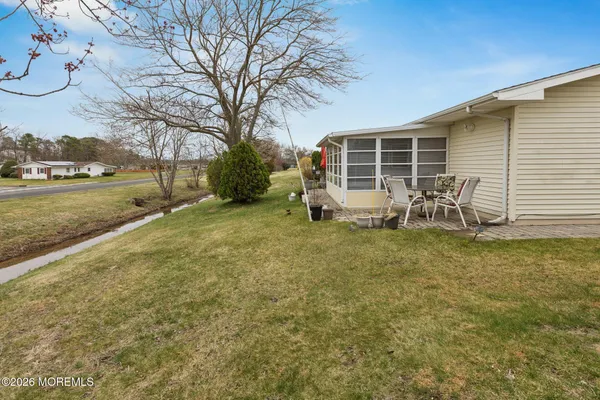 a view of a yard with table and chairs with wooden fence