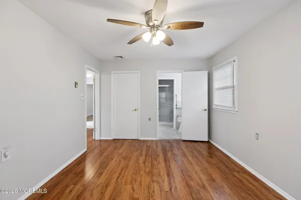 a view of room with ceiling fan and wooden floor