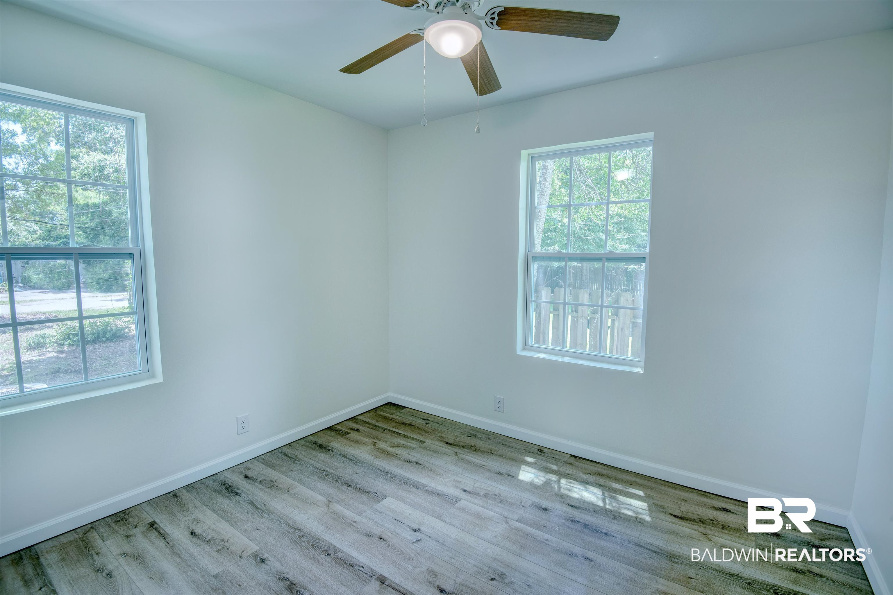 510 East Myrtle Avenue Foley, AL 36535 - Photo 10 of 22 Spare room with healthy amount of natural light, wood finished floors, and a ceiling fan
