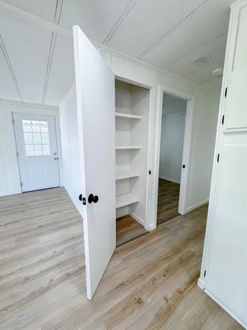 a view of an empty room with wooden floor