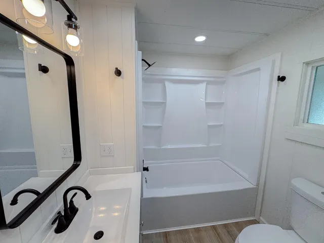 a bathroom with a toilet sink and mirror