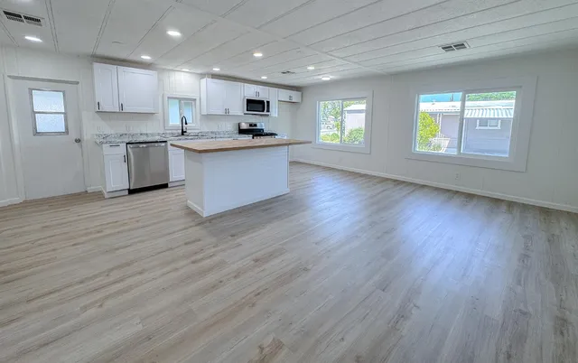 a kitchen with stainless steel appliances a stove top oven a sink and a refrigerator