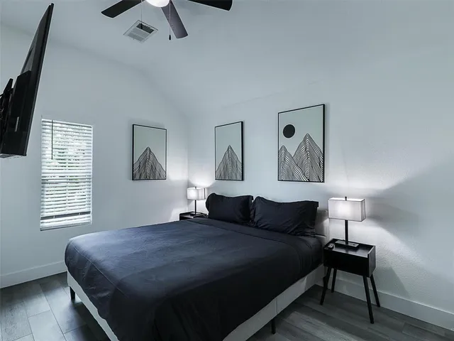 a bedroom with a bed and wooden floor