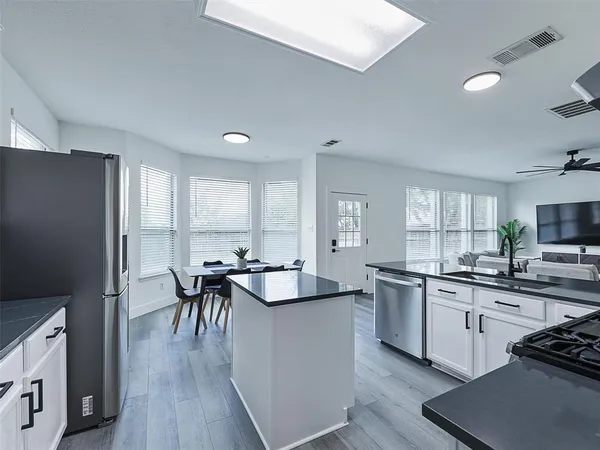a kitchen with stainless steel appliances granite countertop sink stove top oven and cabinets