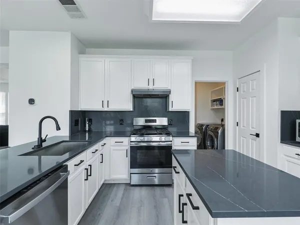 a kitchen with stainless steel appliances granite countertop a sink stove and refrigerator