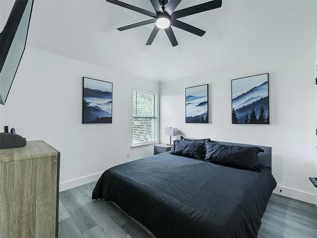 a bedroom with a bed and painting on the wall