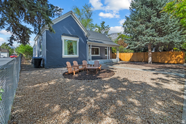 257 200 South Provo, UT 84606 - Photo 2 of 40 Rear view of property featuring a fenced backyard, brick siding, an outdoor fire pit, and a patio area