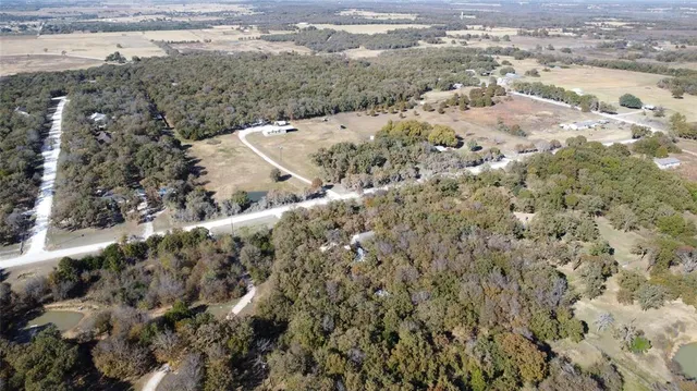 a view of a dry yard with wooden fence