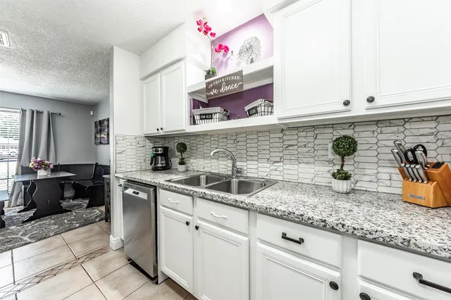 a kitchen with white cabinets and sink
