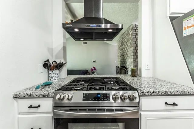 a kitchen with a stove and a white cabinet