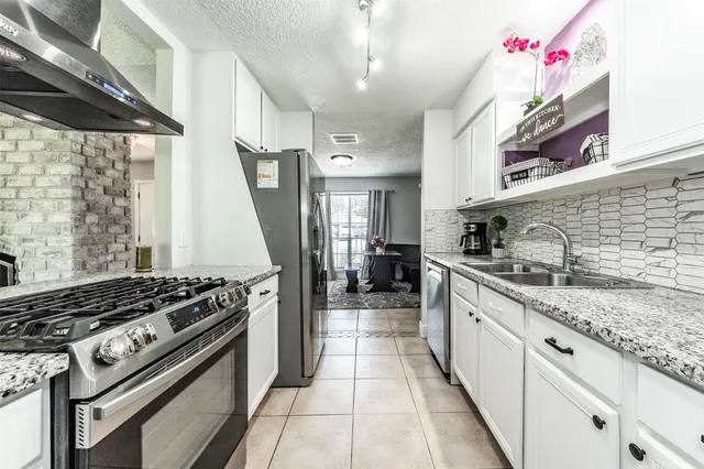 a kitchen with stainless steel appliances granite countertop a stove and a sink