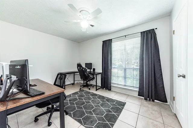 a view of a workspace with furniture and a window