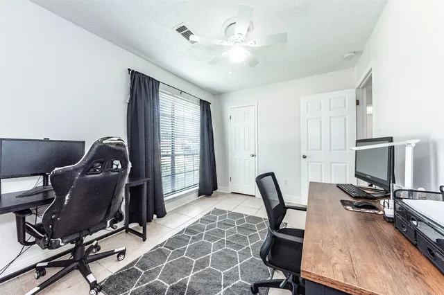 a view of a workspace with furniture and a window