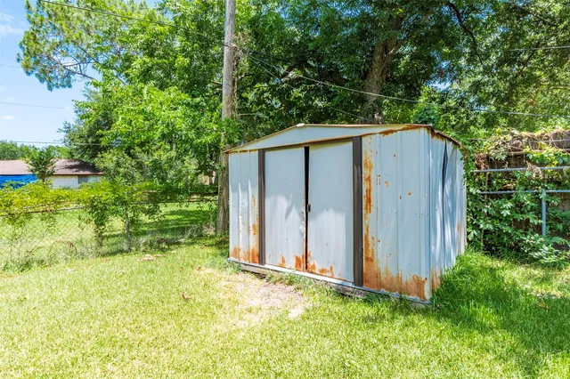 a view of a backyard with potted plants and wooden fence
