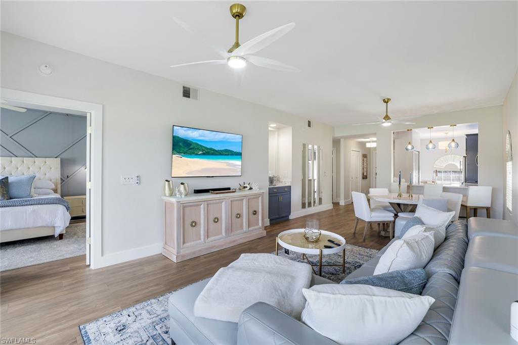555 Augusta Boulevard, Unit 31 Naples, FL 34113 - Photo 2 of 17 Living area featuring baseboards, visible vents, wood finished floors, and a ceiling fan