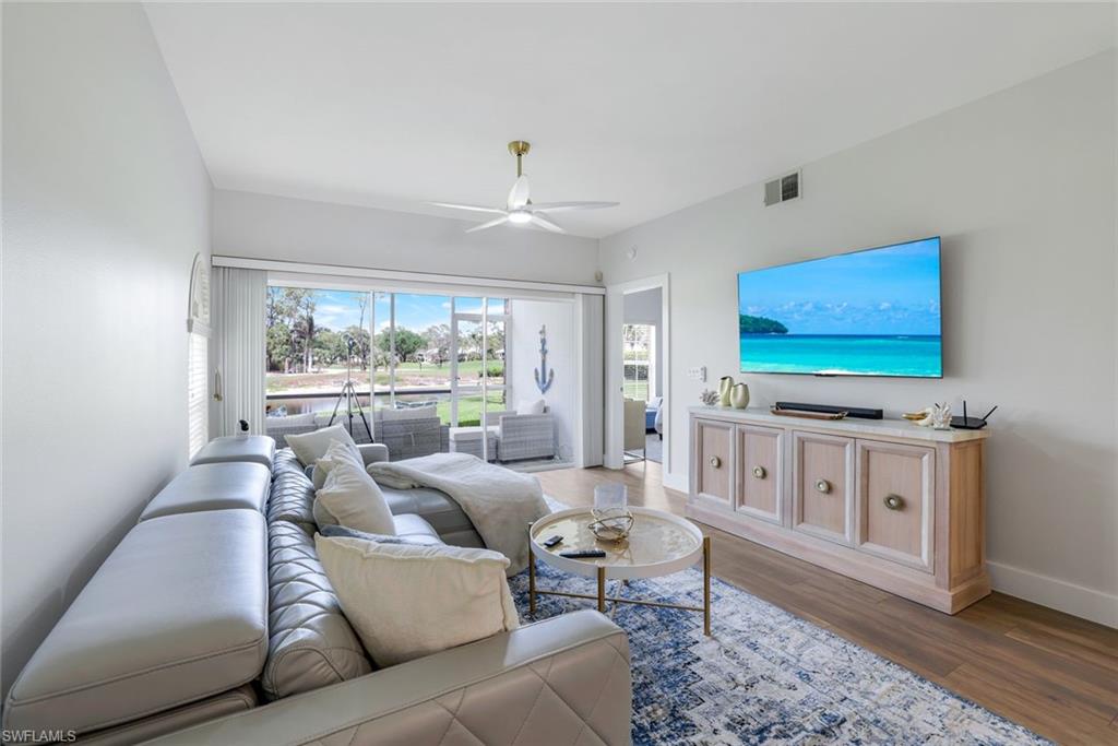 555 Augusta Boulevard, Unit 31 Naples, FL 34113 - Photo 3 of 17 Living room with a ceiling fan, wood finished floors, baseboards, and visible vents