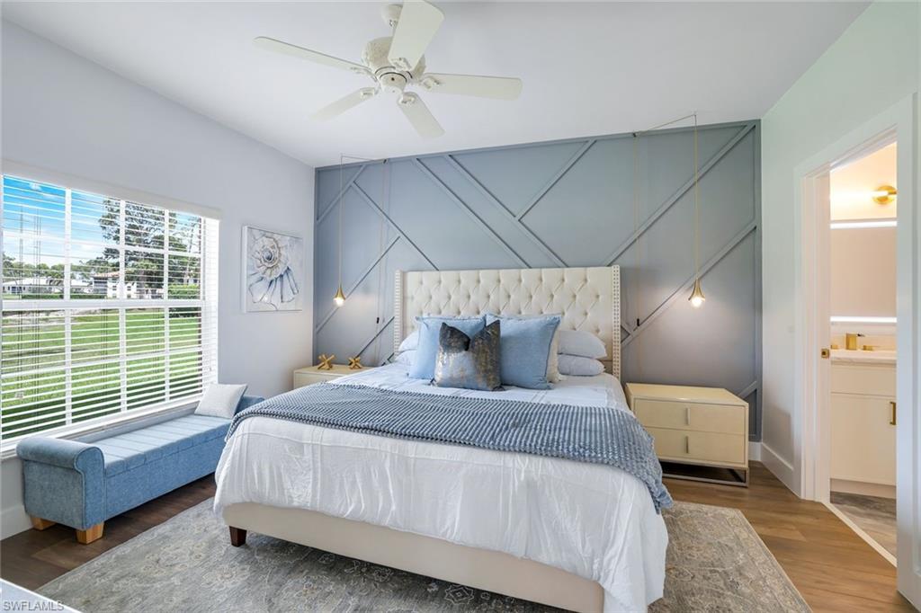 555 Augusta Boulevard, Unit 31 Naples, FL 34113 - Photo 9 of 17 Bedroom with baseboards, ensuite bath, ceiling fan, and wood finished floors