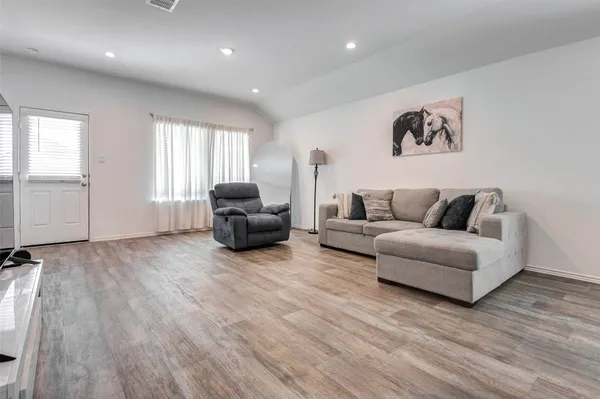 a living room with furniture and a hard wood floor