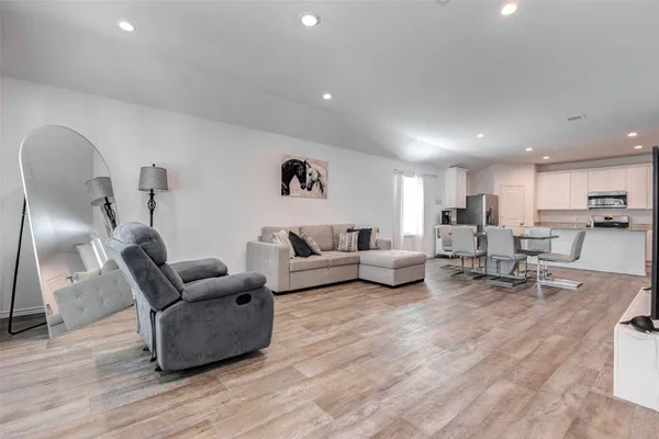 a living room with furniture and a wooden floor