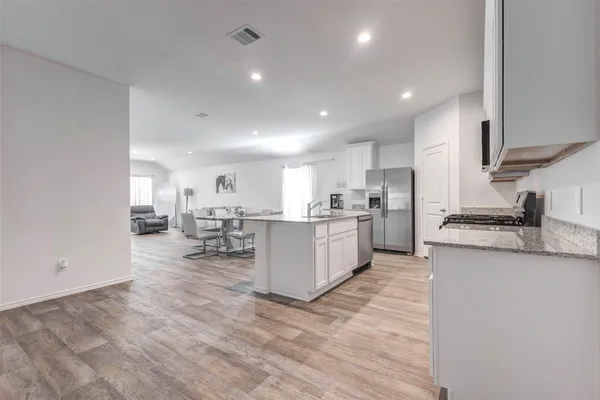 a large white kitchen with lots of counter space and appliances