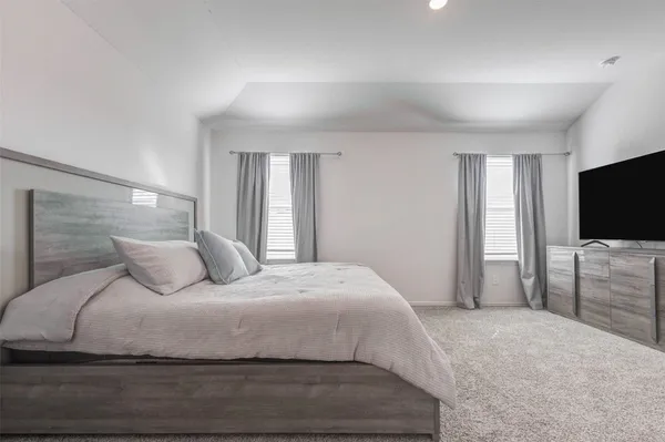 a bedroom with a large bed and a flat screen tv
