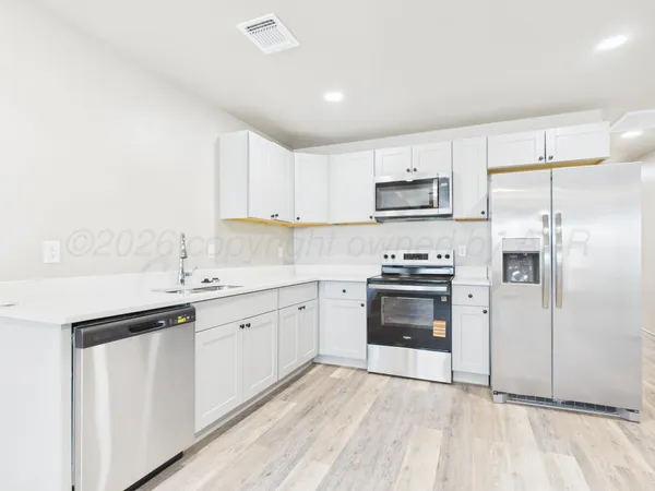 a kitchen with granite countertop a sink stove and refrigerator