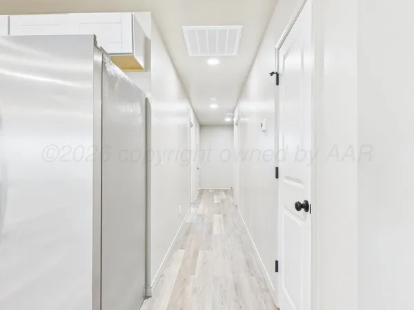 a view of a hallway with wooden floor