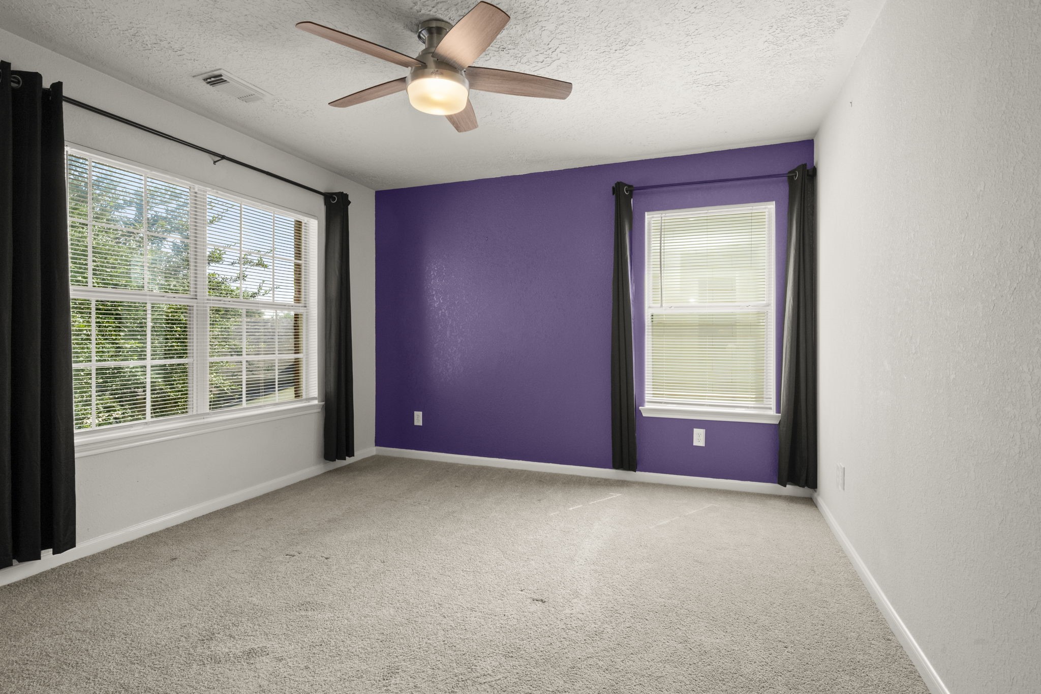 19819 Rippling Brook Lane Tomball, TX 77375 - Photo 24 of 28 Bedroom 3 - Neutral carpet and paint, ceiling fan, accent wall and curtains.