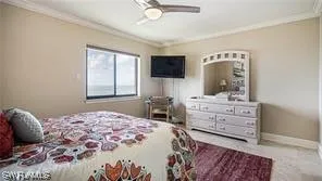 a bedroom with a large bed and a flat tv screen on dresser
