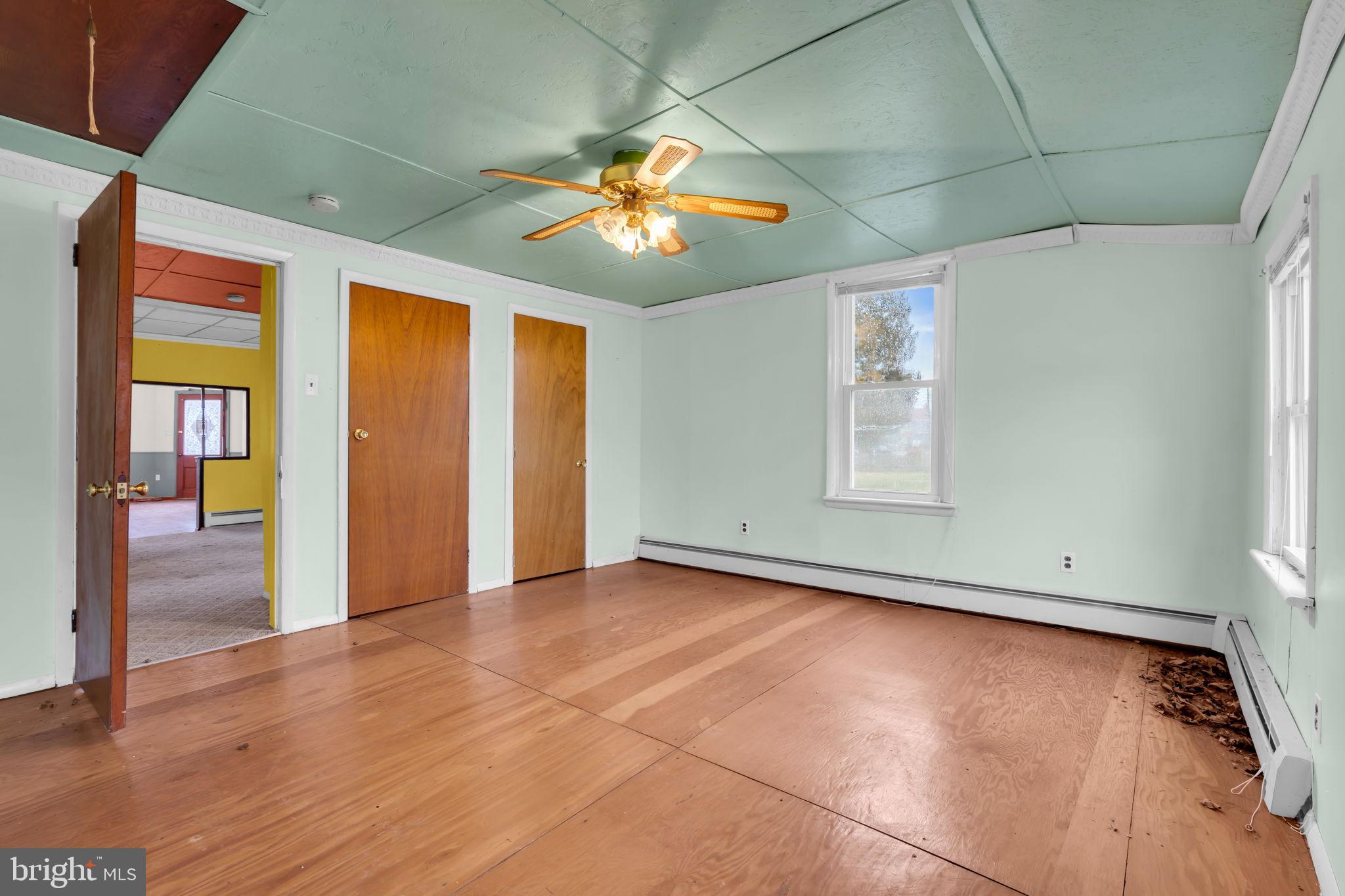 104 Maple Street Clayton, NJ 08312 - Photo 9 of 13 an empty room with wooden floor chandelier and windows