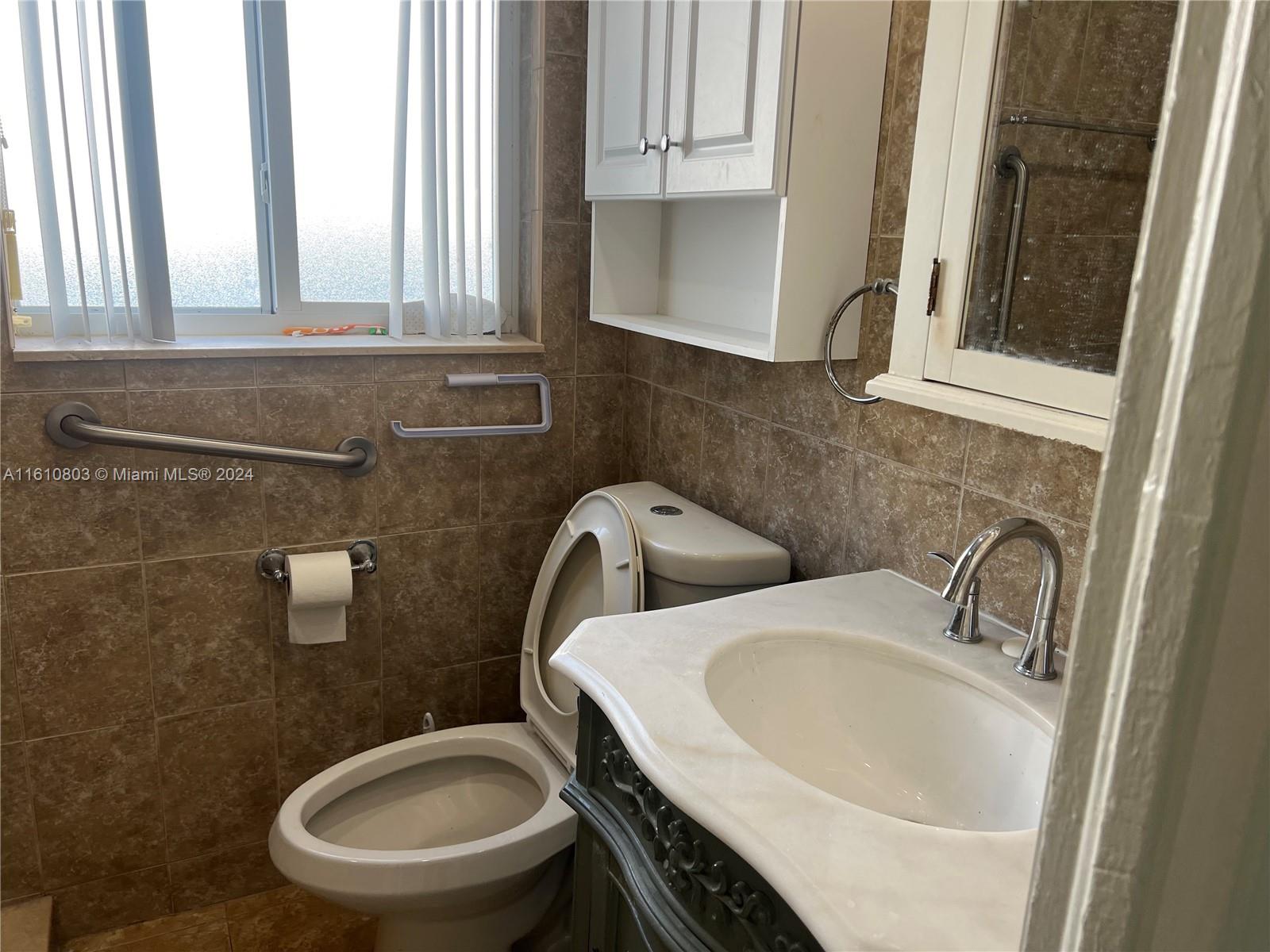 3052 Southwest 6th Street Miami, FL 33135 - Photo 11 of 17 a bathroom with a toilet sink and mirror