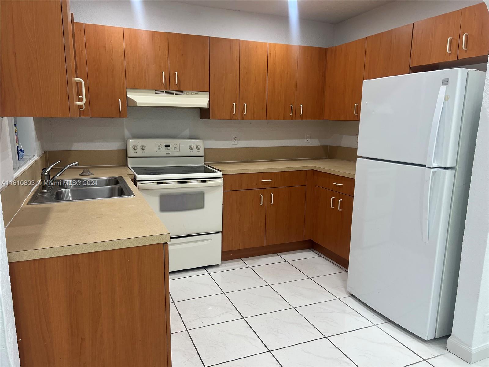 3052 Southwest 6th Street Miami, FL 33135 - Photo 5 of 17 a kitchen with a refrigerator sink and cabinets