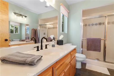 a bathroom with a double vanity sink toilet and shower