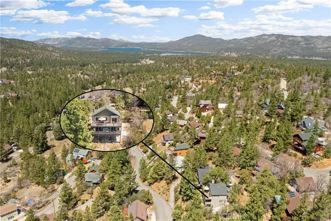 an aerial view of a house with a mountain