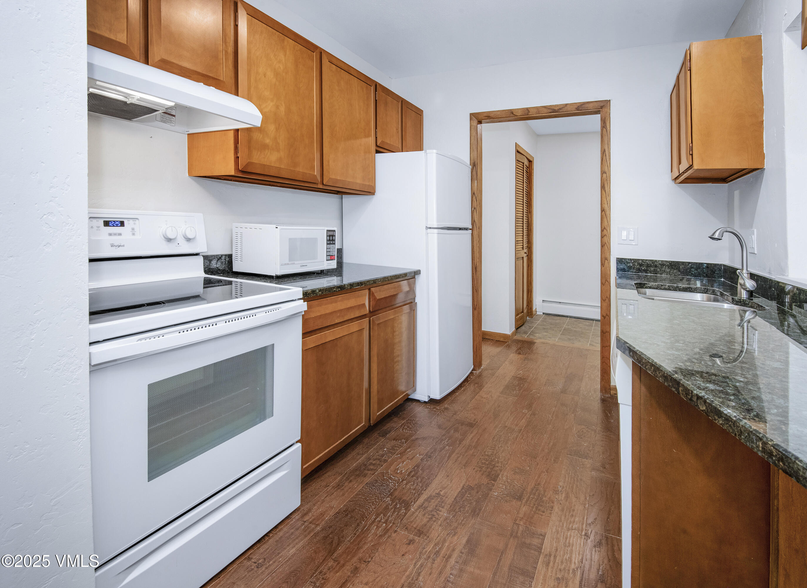 921 Red Sandstone Road, Unit A Vail, CO 81657 - Photo 7 of 26 a kitchen with granite countertop a sink a stove and cabinets
