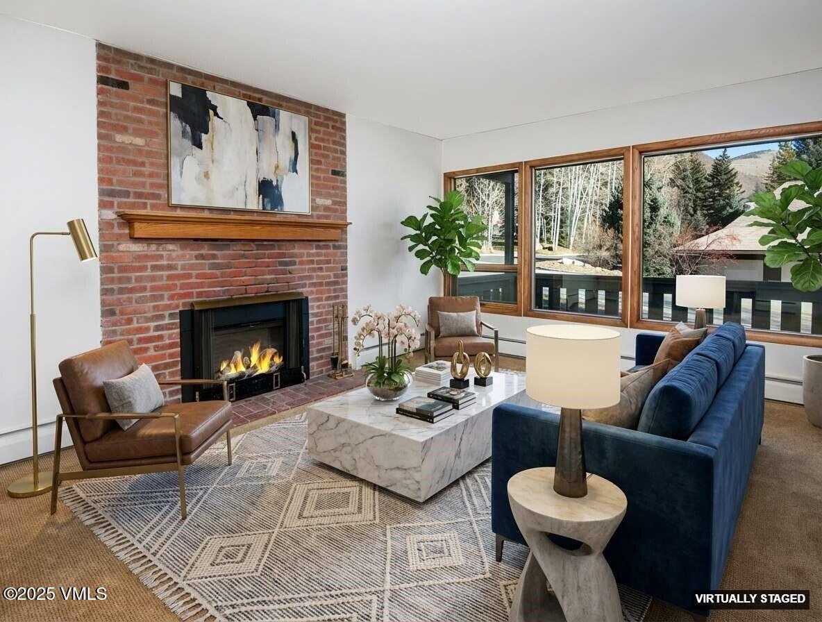 921 Red Sandstone Road, Unit A Vail, CO 81657 - Photo 8 of 26 a living room with furniture a fireplace and a large window