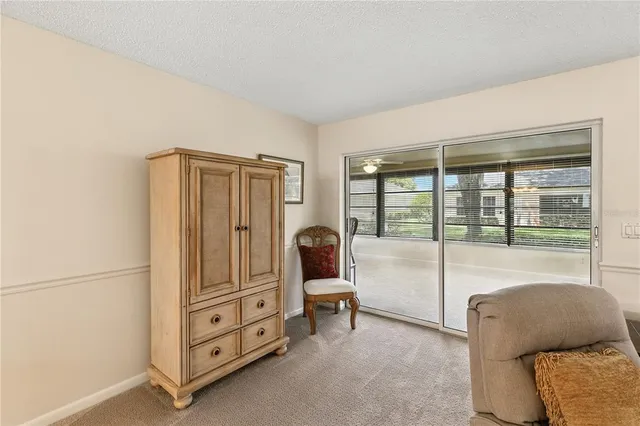a bedroom with a bed a large window and potted plant on the dresser