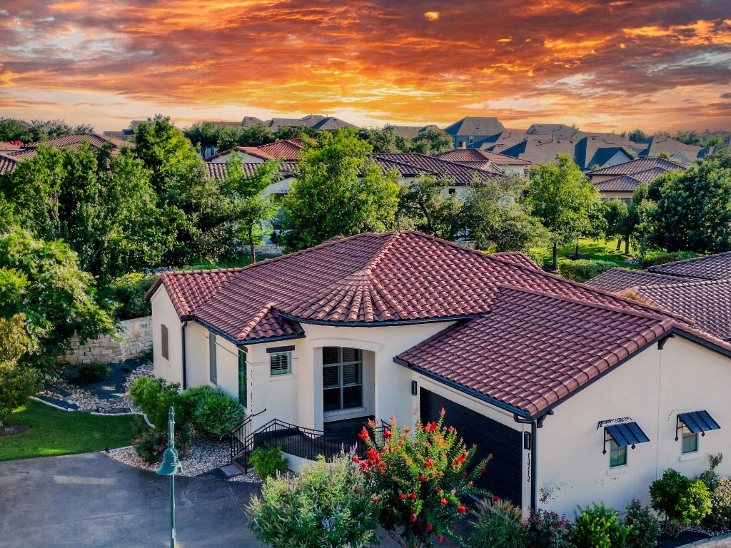 a front view of a house with a yard and mountain view in back