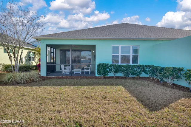 an aerial view of a house with a garden and lake view