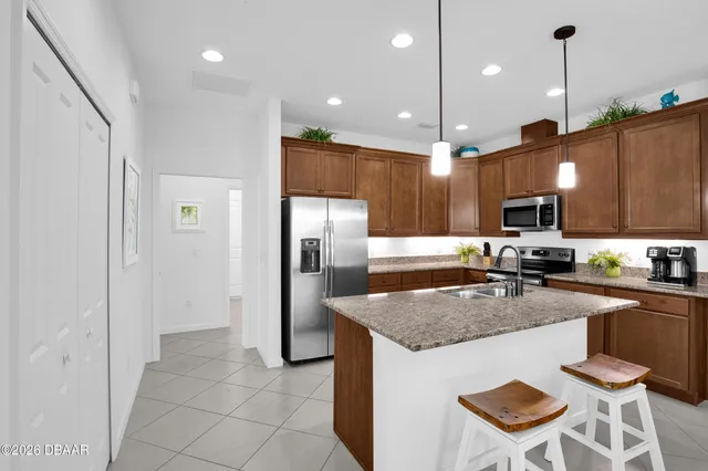 a kitchen with stainless steel appliances granite countertop a refrigerator and a sink