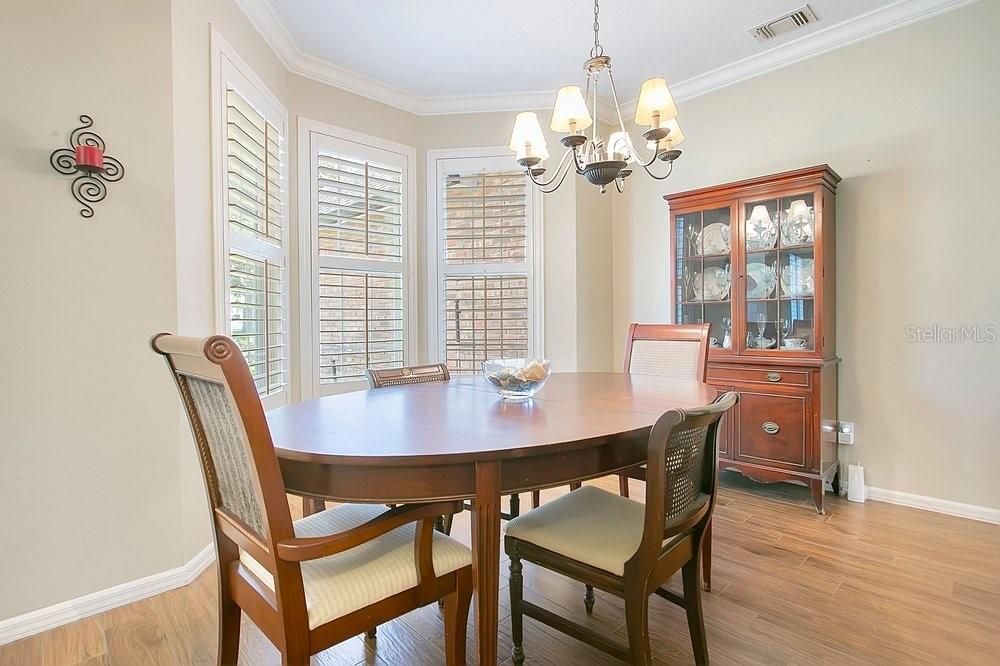 2702 Carter Grove Circle Windermere, FL 34786 - Photo 11 of 42 a view of a dining room with furniture a chandelier and wooden floor