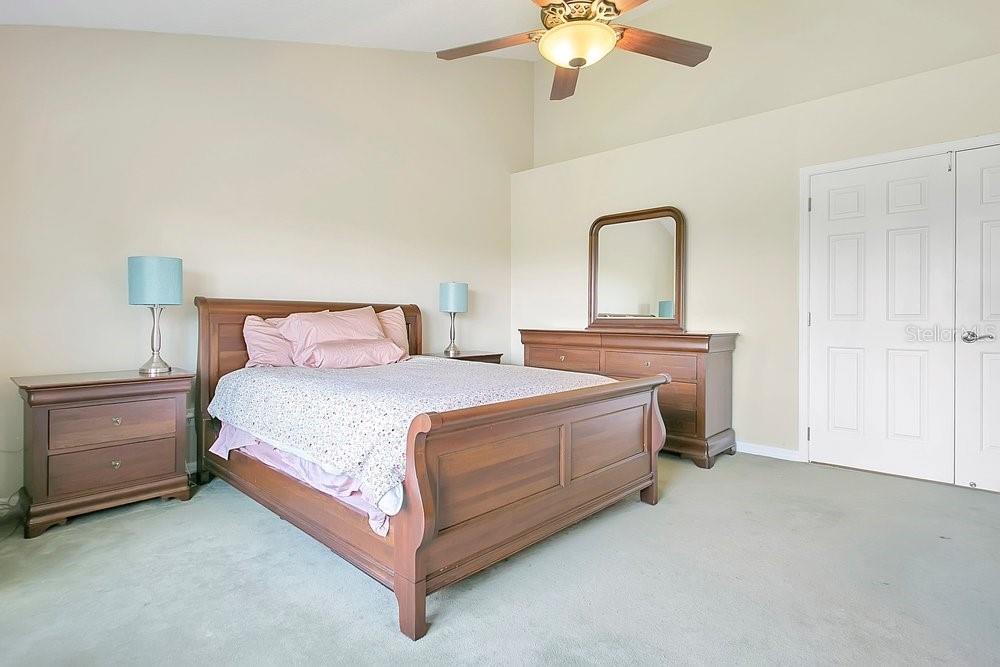 2702 Carter Grove Circle Windermere, FL 34786 - Photo 20 of 42 a bedroom with a bed and a chandelier